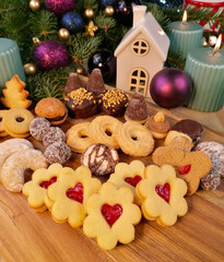 Assorted christmas cookies on a wooden background close-up stock photo images. Festive shortbread biscuits, linzer cookies, candles and purple bauble photo. Template for background, banner, card