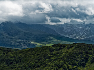 Coomloughra Horseshoe trail. Mountains tower in the background under moody skies, showcasing the rugged beauty of the Irish landscape.