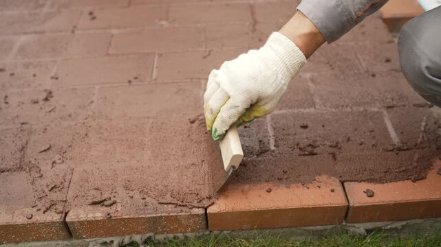 Hand grouting brick paving renovating outdoor patio