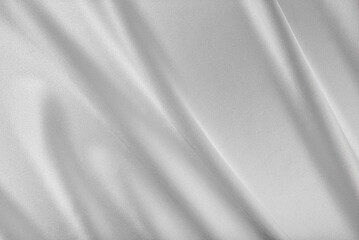 Fototapeta premium Luxurious silver satin fabric with elegant, flowing folds and a soft, shimmering texture.