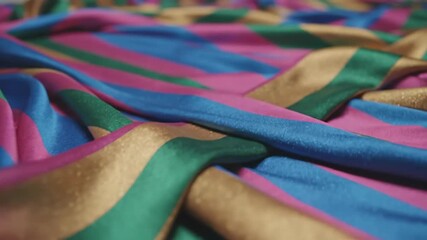 Draped fabric in blue, pink, green, & gold stripes