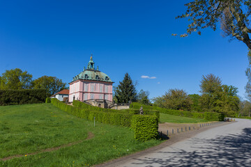 Fasanenschlösschen Pheasant Palace near Moritzburg Castle. Rococo building with a pink facade and turquoise dome against a bright blue sky