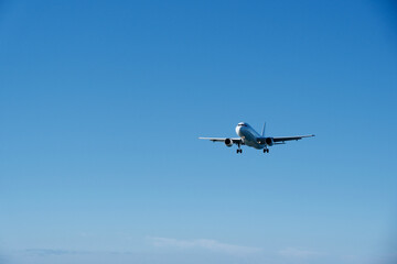 White Plane Approaching Runway Against Blue Sky