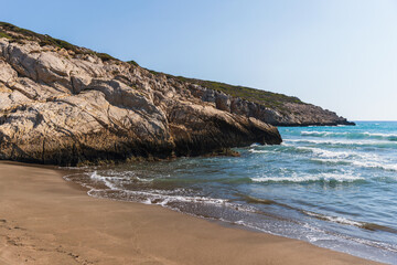 A tranquil coastal scene featuring rugged limestone cliffs. Patara beach landscape