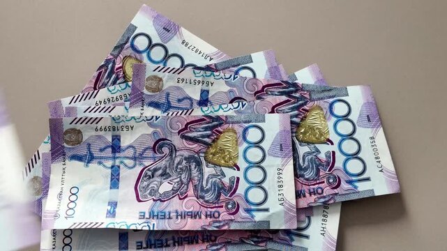 Counting a stack of 10000 kazakhstani tenge banknotes. Close-up view of the national currency of kazakhstan for finance and business concepts