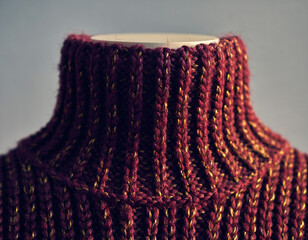 Closeup of a textured, handknitted sweater with a high roll neck. Cozy and warm, perfect for winter designs, fashion editorials, or crafting projects.