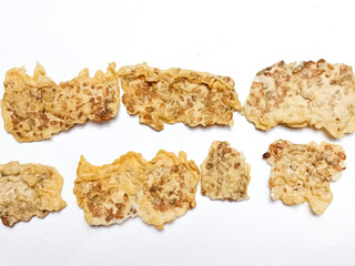 REMPEYEK is commonly referred to peyek as crispy peanut crackers, peanut brittle, or fritters. savory, as one of the Indonesian traditional cracker. Traditional food. Served on white plate background