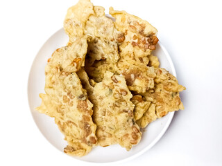 REMPEYEK is commonly referred to peyek as crispy peanut crackers, peanut brittle, or fritters. savory, as one of the Indonesian traditional cracker. Traditional food. Served on white plate background