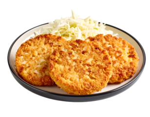 Close-up of crispy, deep-fried Japanese croquettes accompanied by a generous serving of finely sliced cabbage.