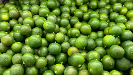 Top view of small limes display in a wet market.