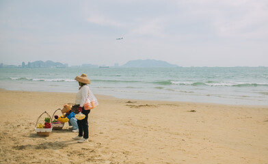 Women with fruit baskets sell on the beach