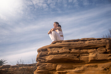 sporty woman sitting on rocks looking at the view, getting away from it all, stress reset