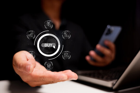 A person extending a hand with a digital "BUY" icon, symbolizing online shopping and technology in a dark environment. - Powered by Adobe