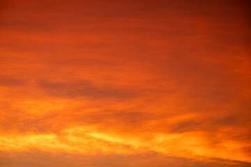 Colorful sunset sky with warm orange and purple clouds creating a dramatic natural background. Soft gradient evening light for nature, travel, landscape and abstract design use, beautiful dark sky