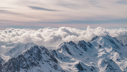 Naklejka premium Snowy mountain peaks emerging through fluffy clouds in soft airy neutral tones, pastel sky at sunrise creating dreamy high altitude alpine landscape