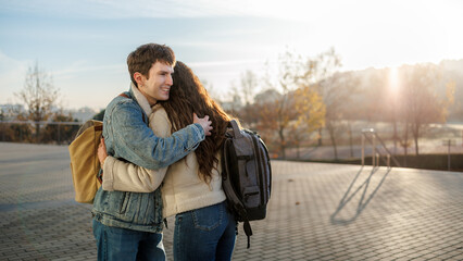 College students embrace outdoors, showing friendship and reunion during autumn