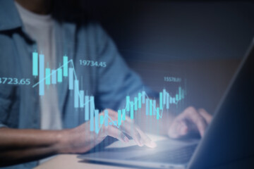 A man is using a laptop or smartphone to stock trading graph, graphic overlay laptop keyboard, finance and investment concept. Economy trends for business, financial charts and digits.