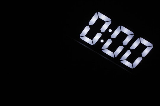 Minimalist digital clock showing 0:00 glowing in the dark