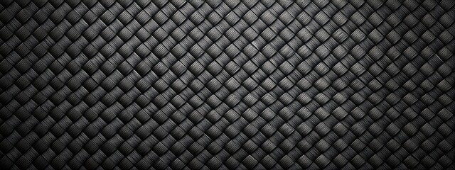 Fototapeta premium Intricate interwoven pattern forming a dark, textured surface. Soft light highlights the raised details