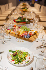 Wide shot of long set table with appetizer and salad assortment - elegant buffet