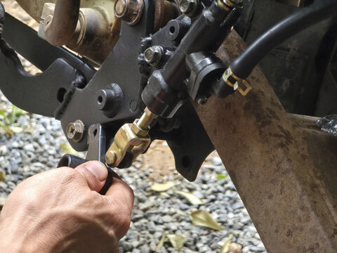 Mechanic hand carefully performs vehicle brake maintenance. Focused repair work on car hydraulic caliper and hose line with special tool. Automotive service detail