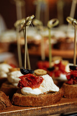 Close-up of canape with cheese and sun-dried tomatoes - appetizing appetizer
