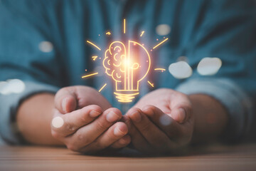 Hands holding a glowing brain and lightbulb symbol representing creativity innovation idea...