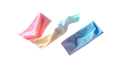 Three colorful, crumpled paper towels float against a stark black background, exhibiting varying shades