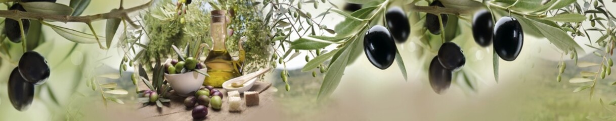 Olive oil bottle with fresh olives and branches on wooden table against soft green orchard background