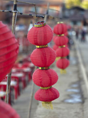 Festive row of hanging red Chinese lanterns for cultural festival celebration. Traditional Asian decoration symbolizing good luck and joy for new year with vibrant background