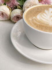 Cup of hot coffee with a bouquet of flowers. Coffee and flowers