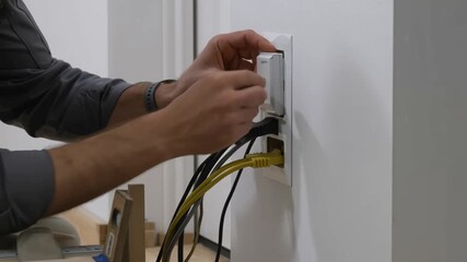 Handyman installing an electrical outlet with a variety of cables in a wall outlet Stock video