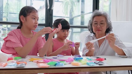 Joyful Generations: A heartwarming scene unfolds as a grandmother and two granddaughters engage in a craft activity, showcasing the beauty of intergenerational connection and creative play.