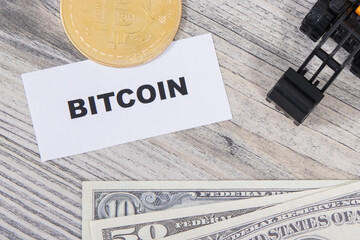 Bitcoin, miniature excavator and dollars. Cryptocurrency. International network payment. Finance concept