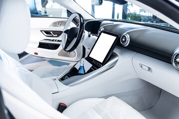 Bright modern car interior with white leather seats and blank central touchscreen, offering clean copy space for advertising, branding, digital app mockups and automotive presentation.