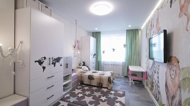 cozy kid room with two beds, white cabinetry, star-patterned rug, mounted TV, plush lion toy, light green curtains, wall art, and a pink-framed desk. Bright and playful
