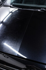 Close-up of car hood after paint correction, showing a 50 50 comparison with restored gloss and surface clarity as preparation before ceramic coating application.