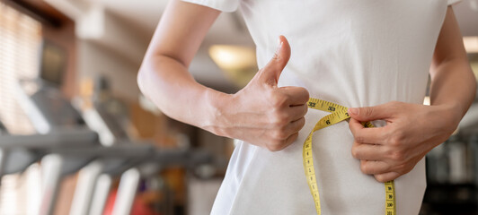 Diet and dieting. Beauty slim female body use tape measure on fitness. Woman in exercise clothes achieves weight loss goal for healthy life, crazy about thinness, thin waist, nutritionist.