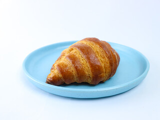 croissant on a blue plate isolated on a white background