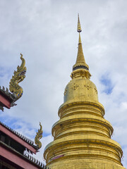 Fototapeta premium Magnificent golden stupa Buddhist temple displays traditional Asian architecture. Sacred and cultural landmark, its historic design reflects spiritual devotion cloudy sky, evoking serene and grand
