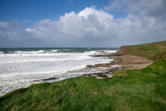 Rugged West coast of Ireland during storm Amy October 2025 with high waves and turbulent, foamy water seen rom Castle Classiebawn Viewpoint and white clouded blue sky