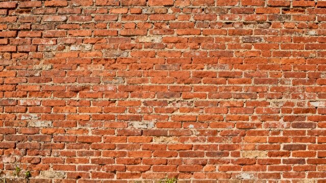 Weathered exterior wall constructed with rough terracotta red bricks and deteriorated light gray mortar. - Powered by Adobe