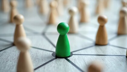 Obraz premium Distinct green wooden figure stands central in complex network. Many neutral wooden figures surround, connected by lines on light textured wooden board. Leadership, teamwork, community, social