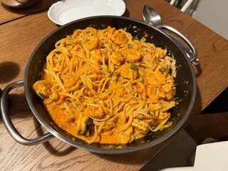 Creamy shrimp Alfredo fettuccine pasta garnished with fresh thyme, parmesan cheese, garlic, olive oil, and a sprinkle of peppercorns.