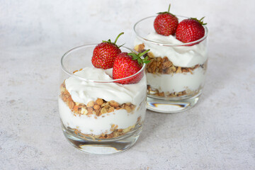 Delicious Strawberry Yogurt Parfaits with Granola in Glasses decorated with fresh strawberries