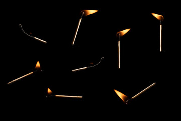 Lit falling match on a black background.