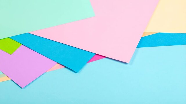 A geometric composition of stacked colored paper in various pastel hues