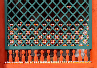 Decoration of a wooden structure with colorful small figures in a complex pattern during daylight