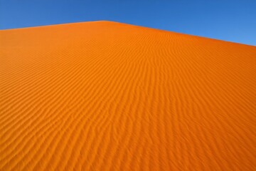 Dramatic Orange Sand Dune under Clear Blue Sky