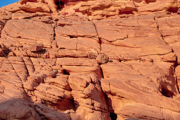 Textured red rock formations under clear blue sky in natural landscape